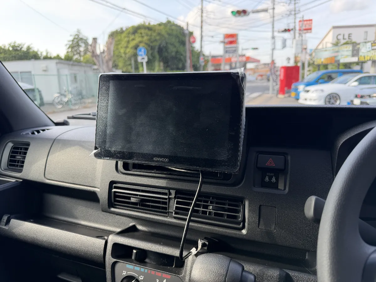 ダイハツ ハイゼットカーゴ S7#0V/W に KENWOOD DMX7509XS を組み合わせると、まず運転席まわりの使い勝手がかなり今どきになります。9インチのフローティング画面は見やすく、スマホ連携もスムーズなので、普段の移動や仕事で使う車ほど便利さを感じやすいです。
このモデルは、ただ画面が大きいだけではなく、オーディオの土台としても使いやすいところがポイントです。ワイヤレスCarPlay/Android Autoに対応しているので、乗り込んでからケーブルをつなぐ手間が減り、音楽や地図アプリも扱いやすくなります。軽バンの車内でも、いつもの曲がもう少し前に出てきたり、声や楽器の輪郭が分かりやすくなる方向へ整えられるのが良いところです。
もちろん、こういうフローティングタイプは取り付け方も大事です。画面の位置や角度、シフトまわりとの干渉、見た目の収まりまで見ながら取り付けないと、せっかくの大画面が使いにくくなってしまうことがあります。
DMX7509XS は、あとからスピーカー交換やアンプ追加なども考えやすいユニットなので、まずは使いやすいメインユニットとして入れて、そこから音の方向性を作っていくのもアリです。ハイゼットカーゴを仕事でも普段使いでも快適にしたい方には、かなり相性のいい選択肢です。