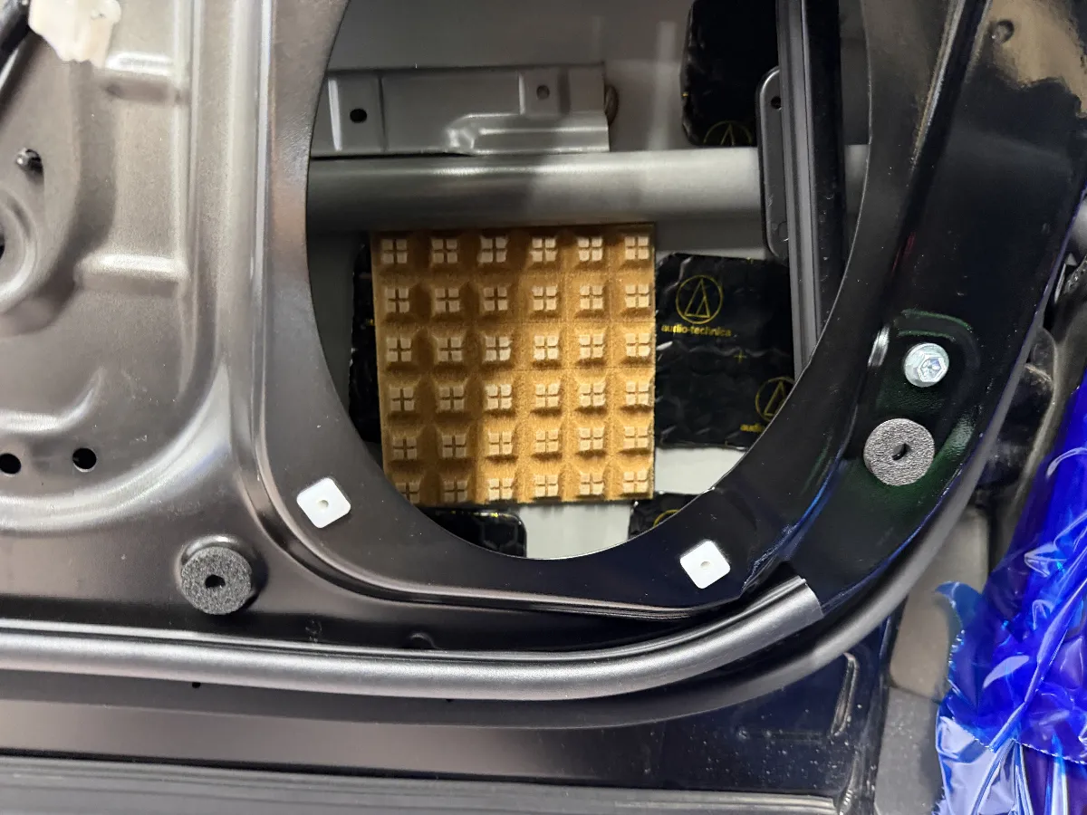 スバル フォレスター SL系 のスピーカーまわりで、見た目には分かりにくいけど音に効いてくるのが ログオンオリジナル スピーカー裏拡散材 です。
スピーカーの裏側は、音が出たあとに空気の動きがぶつかる場所。ここがそのままだと、背面の反射がスピーカーの動きを邪魔して、音が少しにごったり、輪郭がぼやけやすくなることがあります。
スピーカー裏拡散材 は、その背面の音の跳ね返りを整えて、スピーカーが動きやすい状態に近づけるためのパーツです。
派手に見える部品ではありませんが、ボーカルの出方や楽器の余韻、低音の締まり方など、普段聴いている曲の中で「あれ、前よりスッと入ってくるな」と感じやすい部分に効いてきます。
こういうパーツは、ただ貼ればいいというより、スピーカー位置やドア内部の形状を見ながら施工するのが大事です。
せっかくスピーカーを鳴らすなら、ユニット本体だけでなく、その後ろ側まできちんと整えてあげる。フォレスター SL系 で音をもう少し気持ちよくしたい時には、こういう見えない部分の積み重ねがかなり大切になります。
