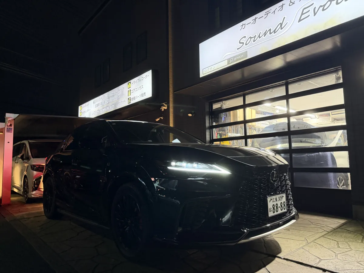 東京都江東区からお越しいただいたお客様の レクサス RX ALA/ALH1# をお預かりし、フロントまわりを中心に使い勝手に関わるアイテムを施工させていただきました。見た目を大きく変える内容ではありませんが、日々の運転で違いを感じやすい組み合わせです。
今回取り付けを行ったのは、以下の3点です。

ユピテル レーザー&レーダー探知機 ZK3100 をフロントへ取り付け
エンラージ レクサスRX/NX 14インチ ディスプレイオーディオ 対応 TVナビキャンセラー Ver.3.0 TV-10 をインストール
エンラージ オートライトセンサーカバー 取付簡単 エラー防止 特殊加工 を装着

レーザー&レーダー探知機 ZK3100 は、視認性や使いやすさを考えながら、車内で違和感の出にくいよう取り付け位置を調整しています。あわせて、TVナビキャンセラー Ver.3.0 TV-10 を導入し、ディスプレイオーディオまわりの使い勝手も整えました。さらに オートライトセンサーカバー も装着し、センサーまわりの保護と誤作動対策まで含めて施工しています。
フロントまわりの作業は、機能面だけでなく見え方や収まり方でも印象が変わります。今回も車両とのバランスを見ながら、できるだけ自然に仕上がるよう進めました。
普段よく使う装備だからこそ、取り付け後の使いやすさは大事なポイントです。今回も実用性を意識した内容で、すっきりとした形にまとまりました。
